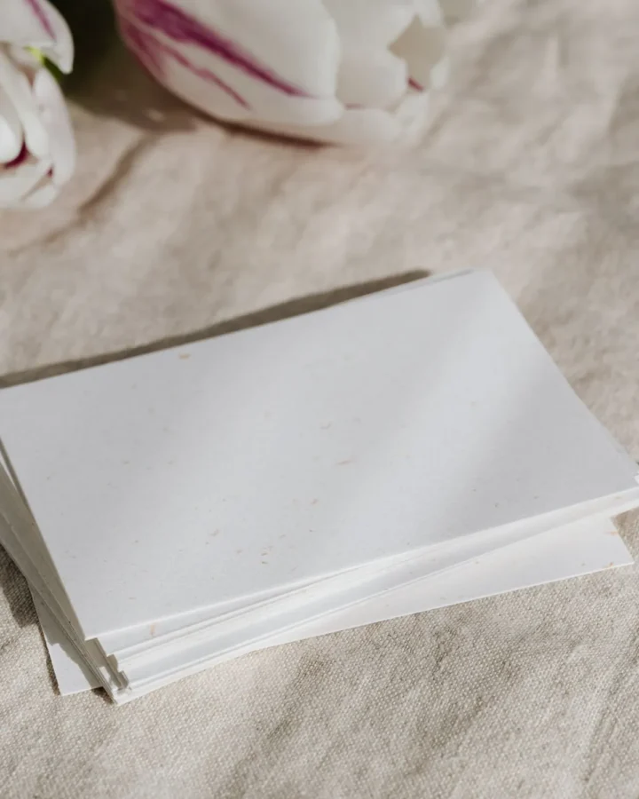 Stack of white business cards on natural linen