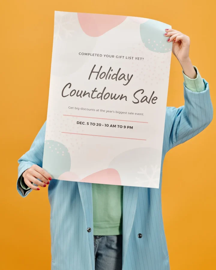 Person holding a printed holiday sale flyer