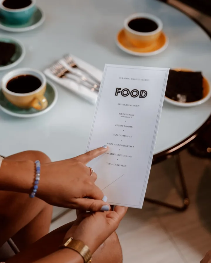 Printed cafe menu card held at a table