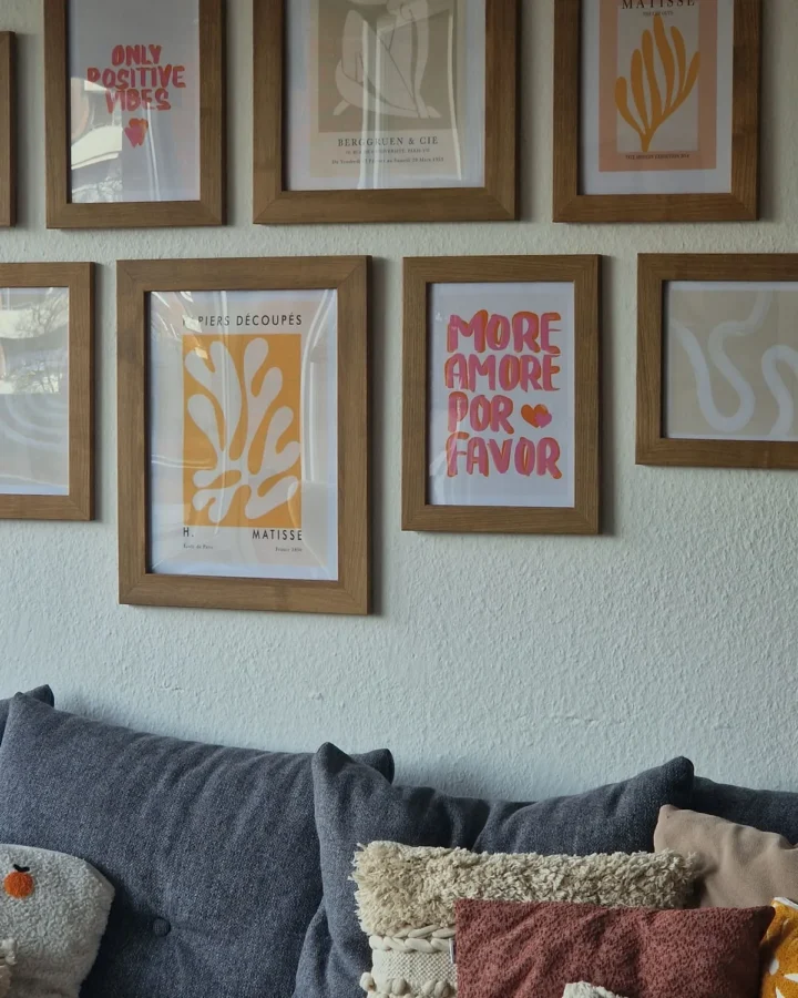 Framed fine art prints above a sofa